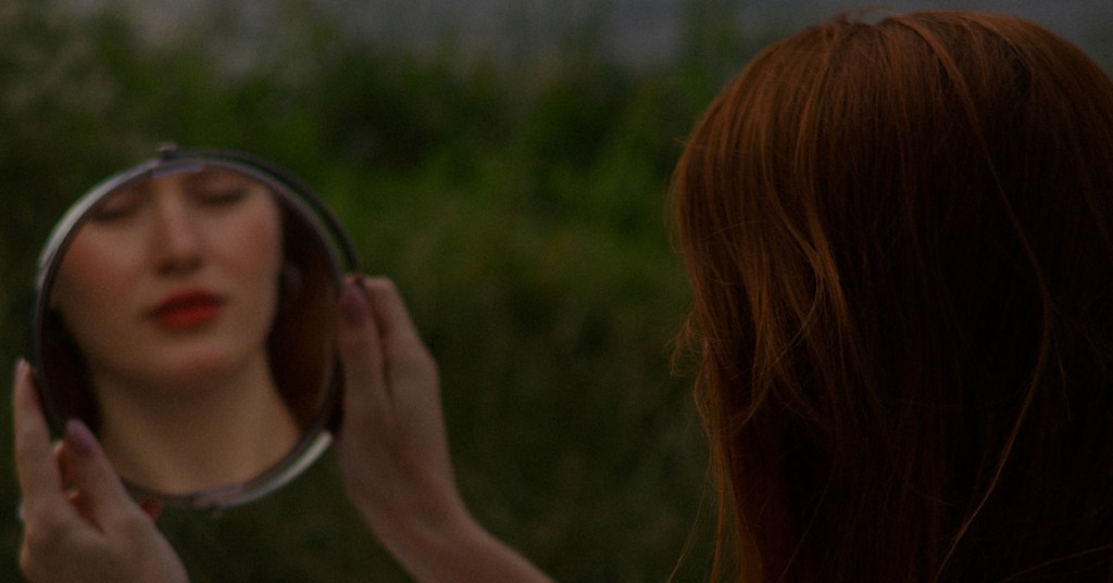 A woman looking in a mirror for answers